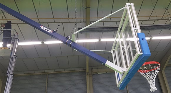 Montage d'un but de basket charpente dans un gymnase.