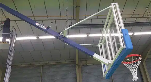 Montage d'un but de basket charpente dans un gymnase.