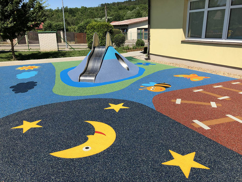 Sol EPDM dessiné avec lune et étoiles autour d'un toboggan dans une cour