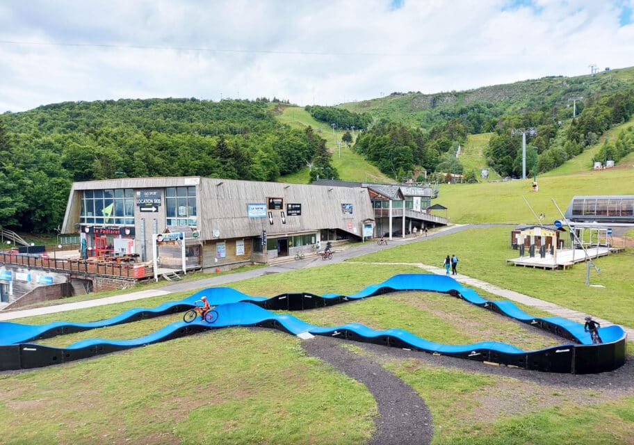 Pumptrack bleue en enrobé au pied des pistes d'une station de montagne