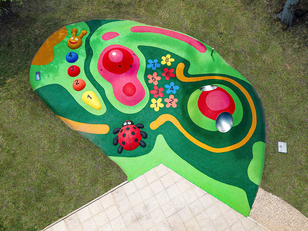 Vue aérienne d'une aire de jeux sur mesure en sol coulé vert à motifs
