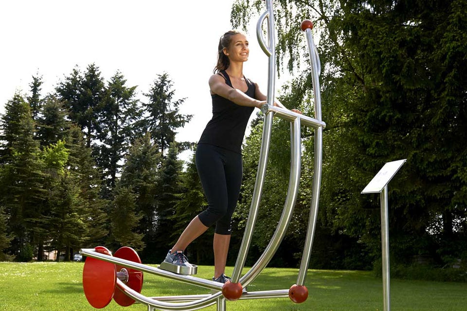 Une fille sur aménagement de gym outdoor dans un parc