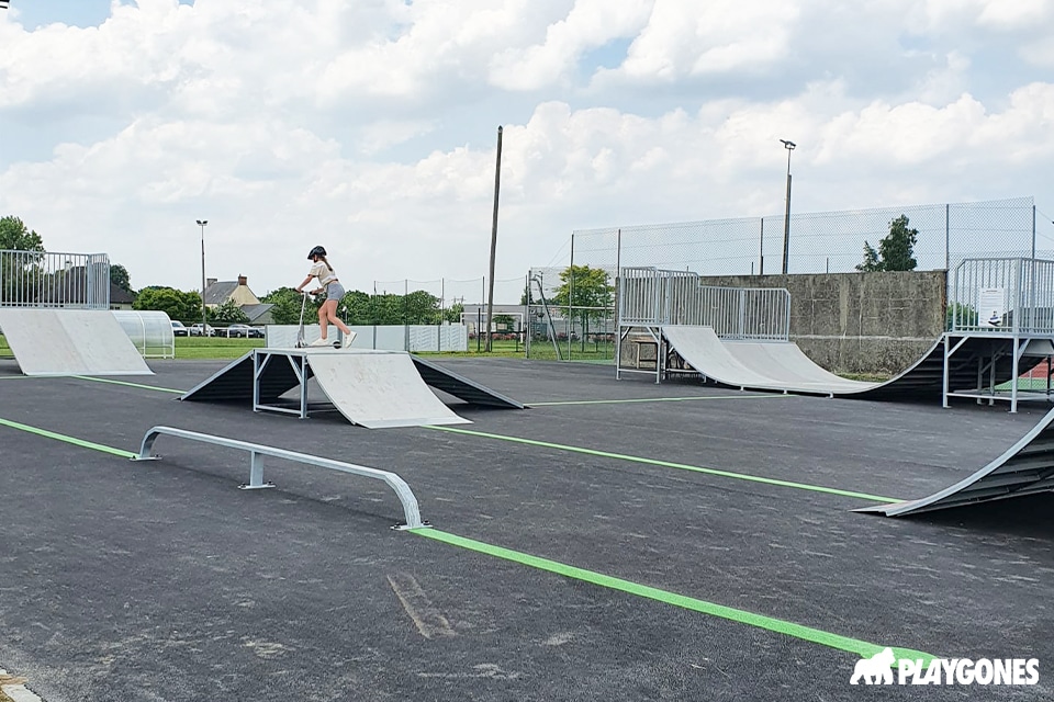 Une petite fille sur le skatepark de Caumont-sur-Aure avec des lignes design actif au sol