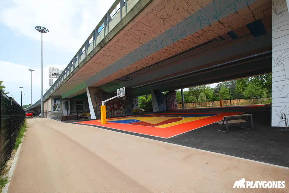 terrain de basket couvert et éclairé sous un pont pour une pratique toute l'année