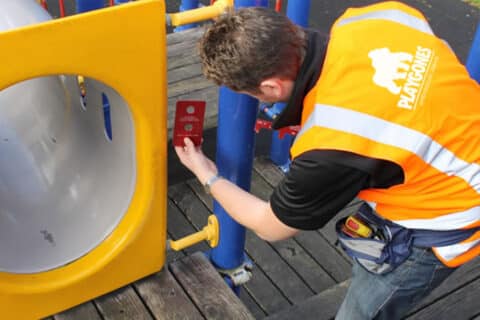 Technicien Playgones inspectant un équipement d'aire de jeux