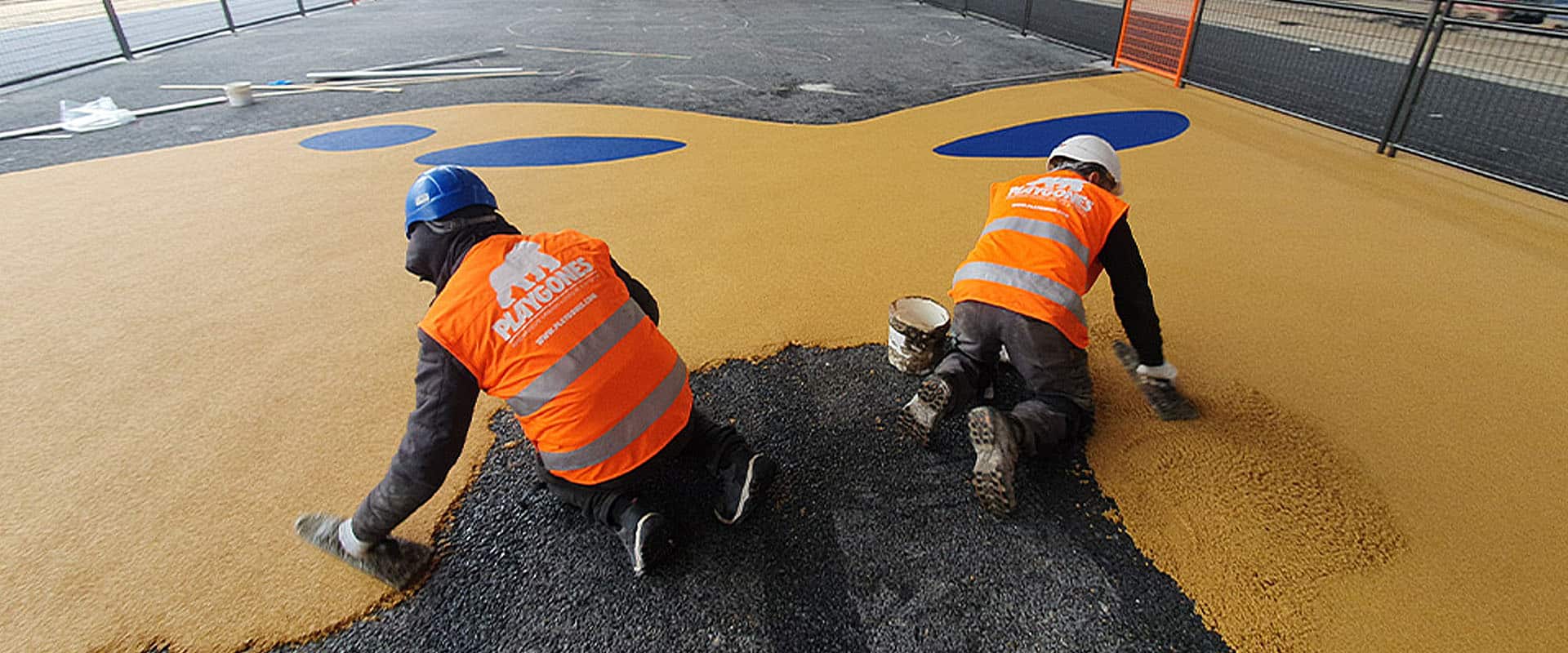 Techniciens talochant un sol amortissant EPDM coulé en place