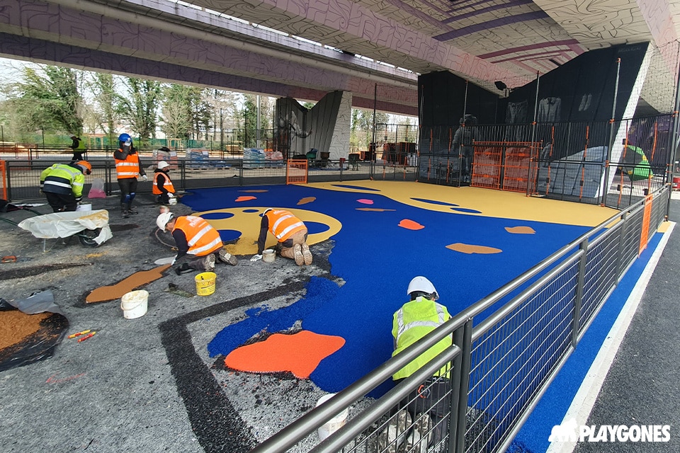 terrain-multisport-ouvrier-pose-epdm-bleu ouvriers posant de l'epdm sur un terrain de sport