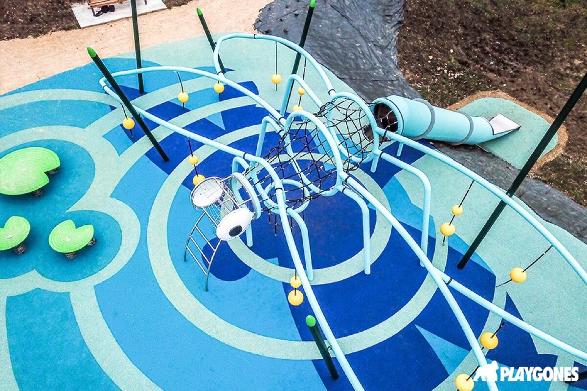 Vue aérienne d'une aire de jeux sur sol coulé bleu à motifs