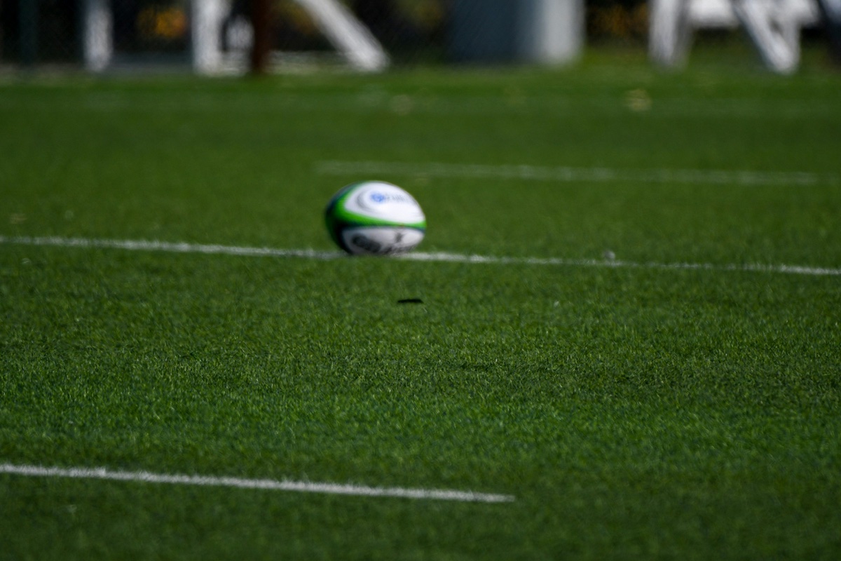 dimensions-terrain-rugby-poteaux-but-gazon.jpg Poteaux de but de rugby en H sur gazon — ecartement interieur 5,60 m, barre transversale a 3 m, hauteur minimale reglementaire 10 m pour matchs officiels FFR