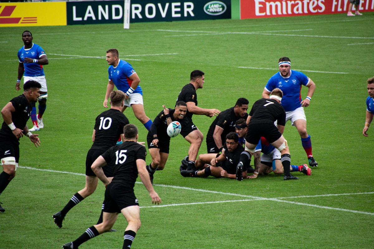 dimensions-terrain-rugby-vue-aerienne-pelouse.jpg Vue aerienne d'un terrain de rugby sur pelouse naturelle — aire de jeu 94-100 m x 68-70 m avec lignes de touche et zones d'en-but conformes aux regles World Rugby