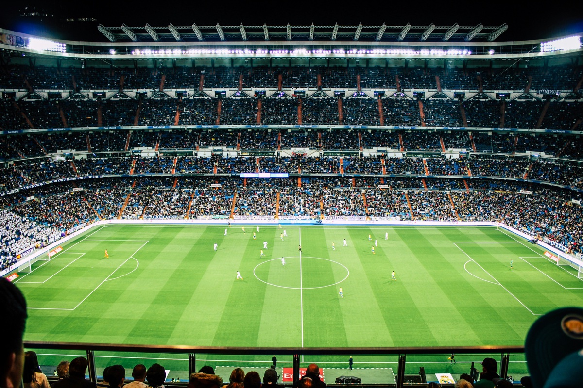 Terrain de football à 11 — dimensions officielles IFAB Vue depuis les tribunes d'un grand stade : terrain de football à 11 avec toutes les lignes réglementaires