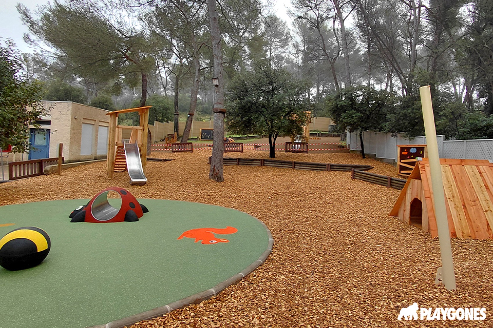 Sol EPDM ludique et copeaux de bois dans une cour oasis vegetalisee