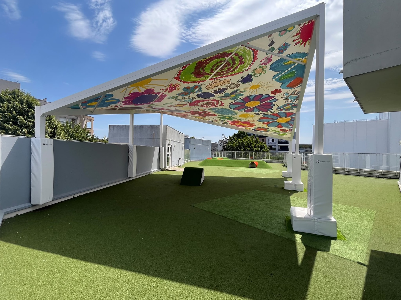 Voile d ombrage fleurie multicolore au-dessus d une aire de jeux