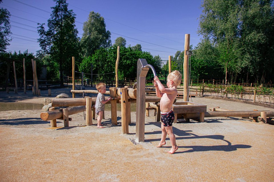 Enfants jouant avec une pompe à eau en bois Boerplay