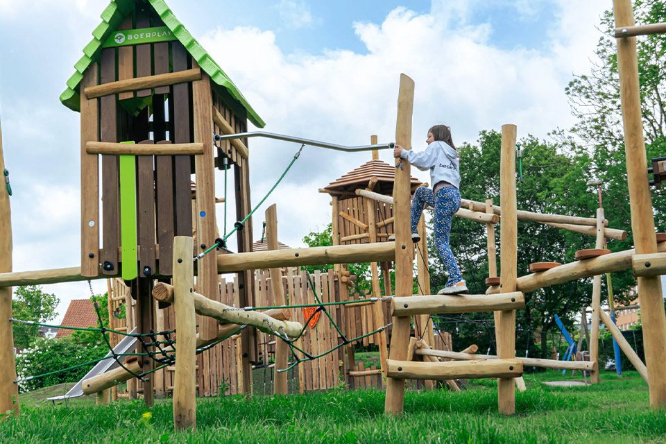 Enfant grimpant sur une tour d'escalade en bois Boerplay