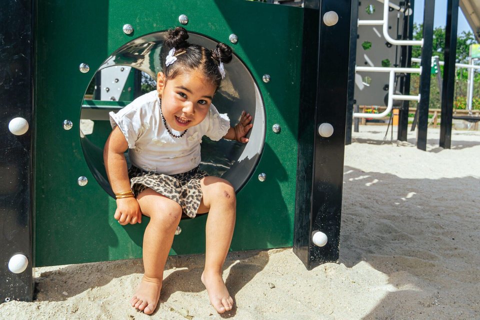Enfant sortant d'un tunnel de jeu Boerplay dans le sable