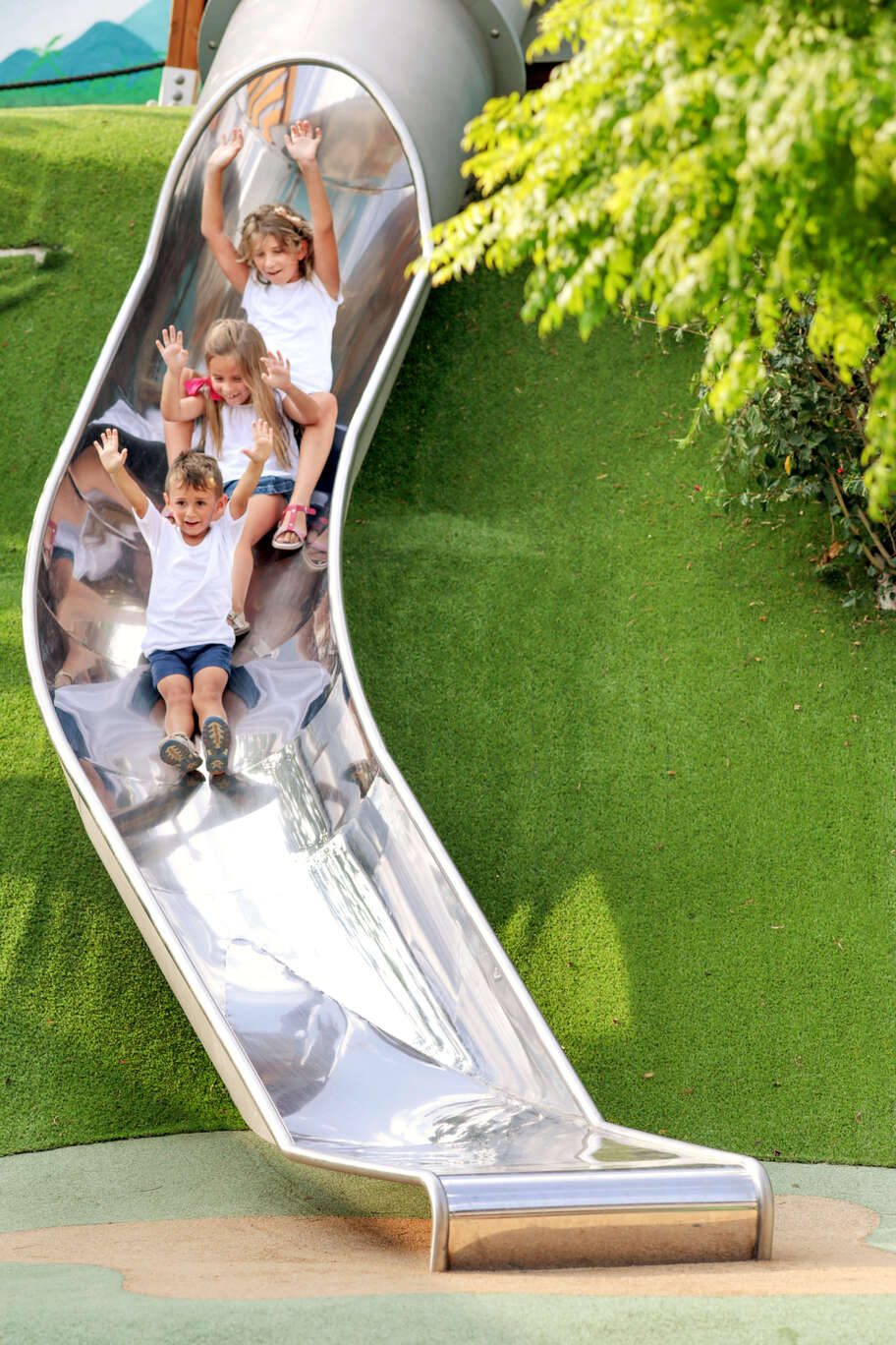 Enfants descendant un large toboggan inox Galopin