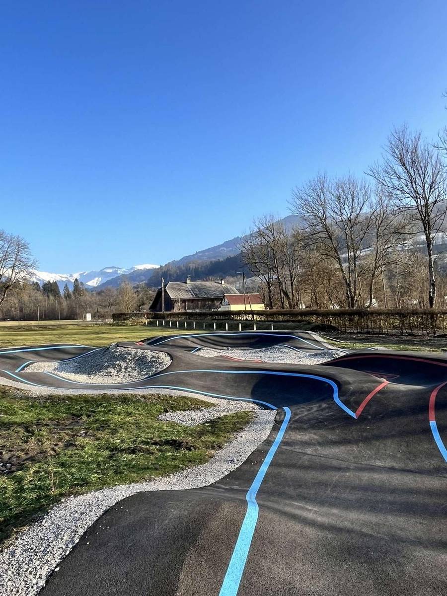 Pumptrack en enrobé de Taninges (Haute-Savoie) avec lignes de marquage bleues et vue sur les montagnes