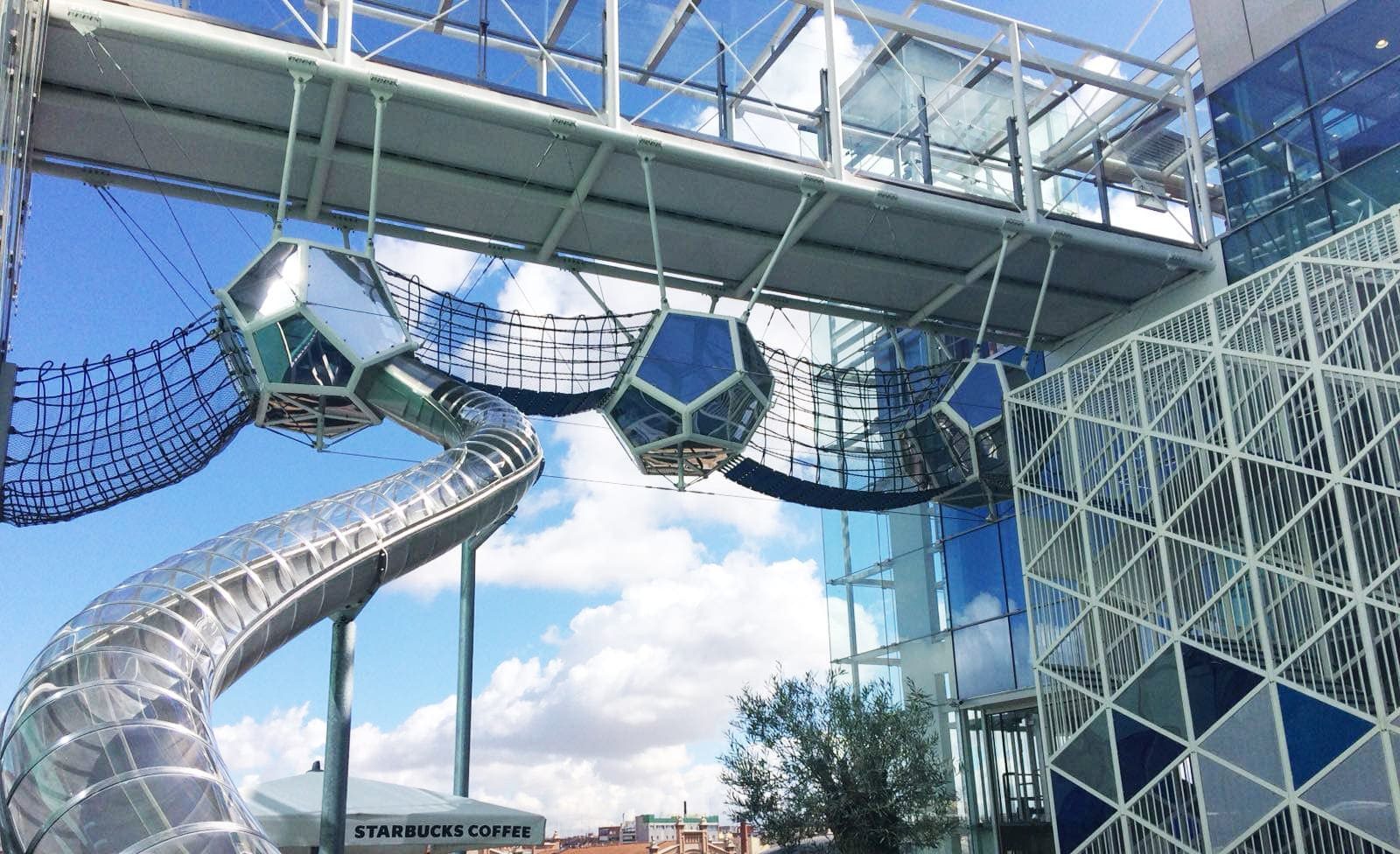 Structure Xogo sur mesure de Galopin : nids suspendus et toboggan géant sous verrière de centre commercial