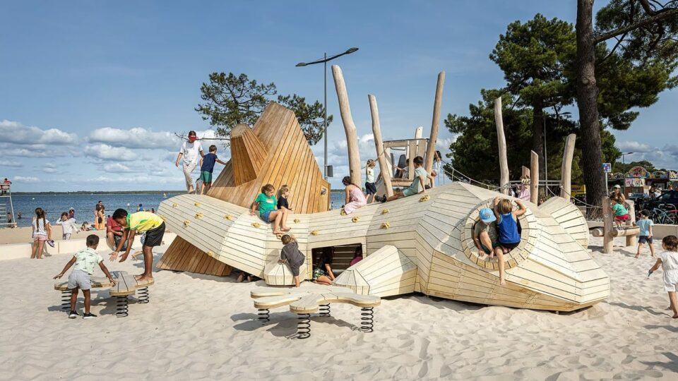 Aire de jeux sur-mesure en forme de triton géant au bord d'une plage