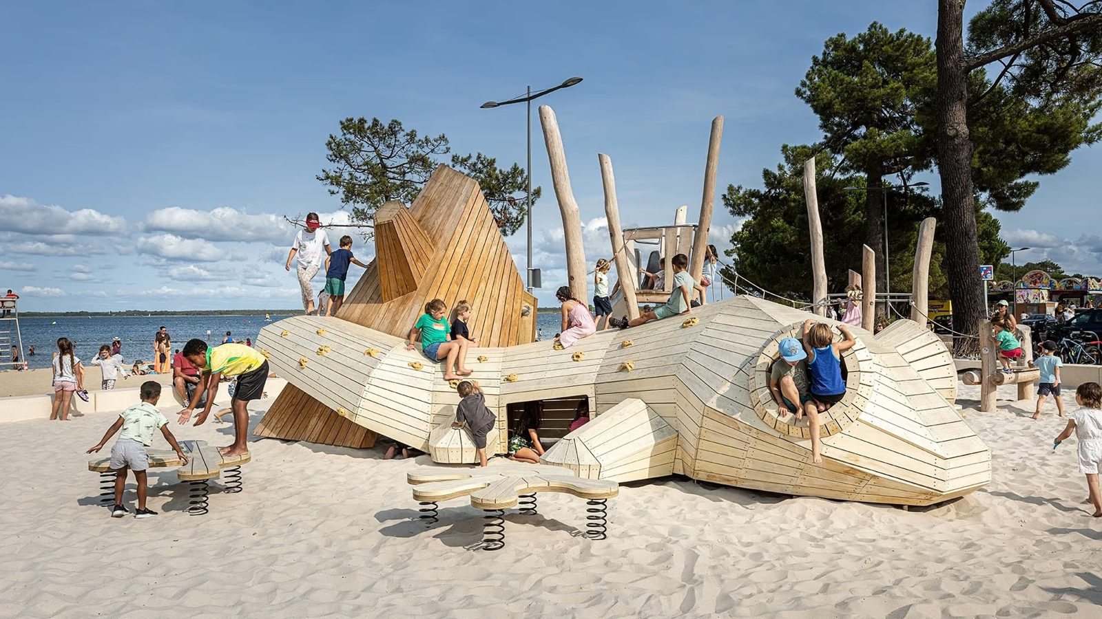 Aire de jeux sur-mesure en forme de triton géant au bord d'une plage