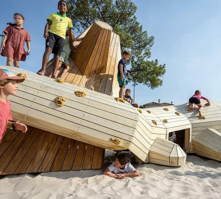 Enfants jouant sur le triton géant en bois