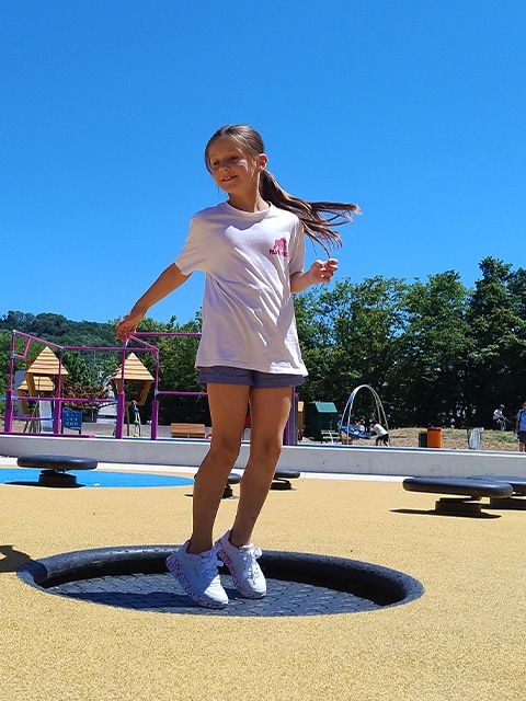 Une fille saute sur un trampoline enterré