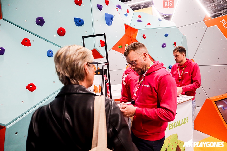 Accueil d'une visiteuse sur le stand escalade